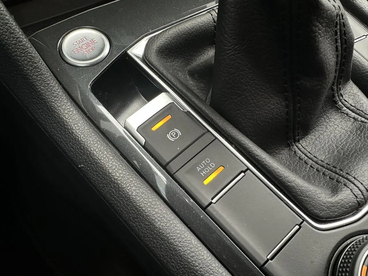 Gros plan sur la console centrale noire du SEAT Tarraco 2024, avec frein électrique et bouton start/stop visibles.