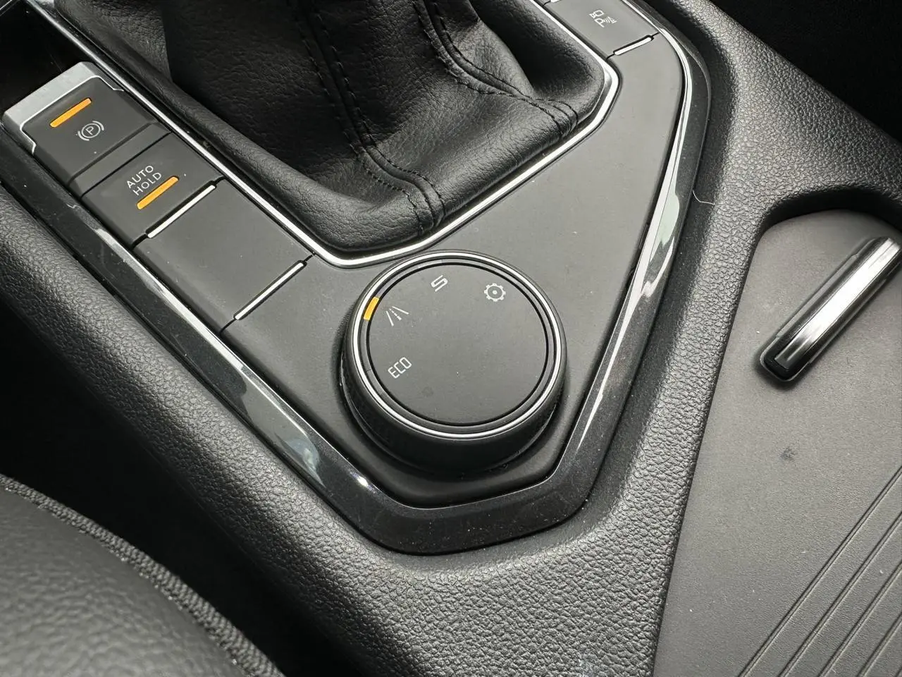 Gros plan sur la molette de sélection de mode de conduite et frein à main électrique dans le console centrale du SEAT Tarraco.