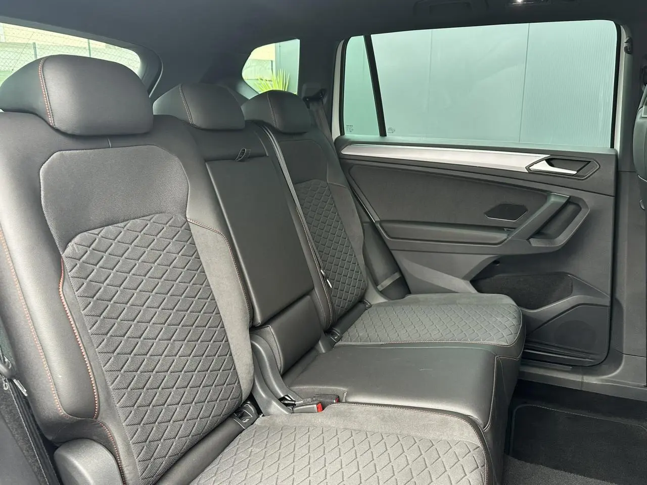 Vue latérale droite des sièges arrière en cuir noir avec surpiqûres rouges du SEAT Tarraco 1.4 e-Hybrid 2024