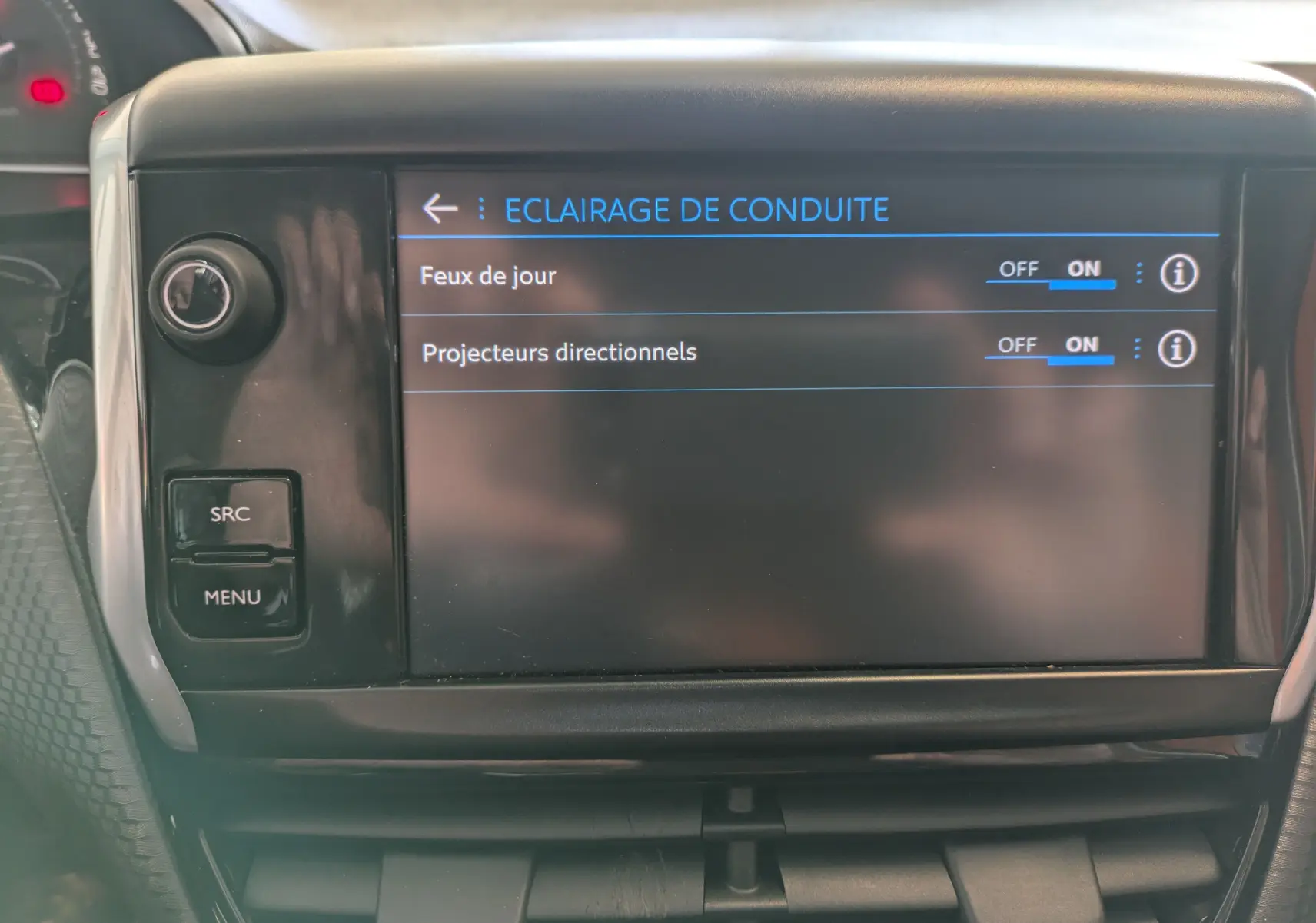 Écran tactile central de la Peugeot 208 Allure 2019 affichant les réglages d’éclairage de conduite, intérieur noir.