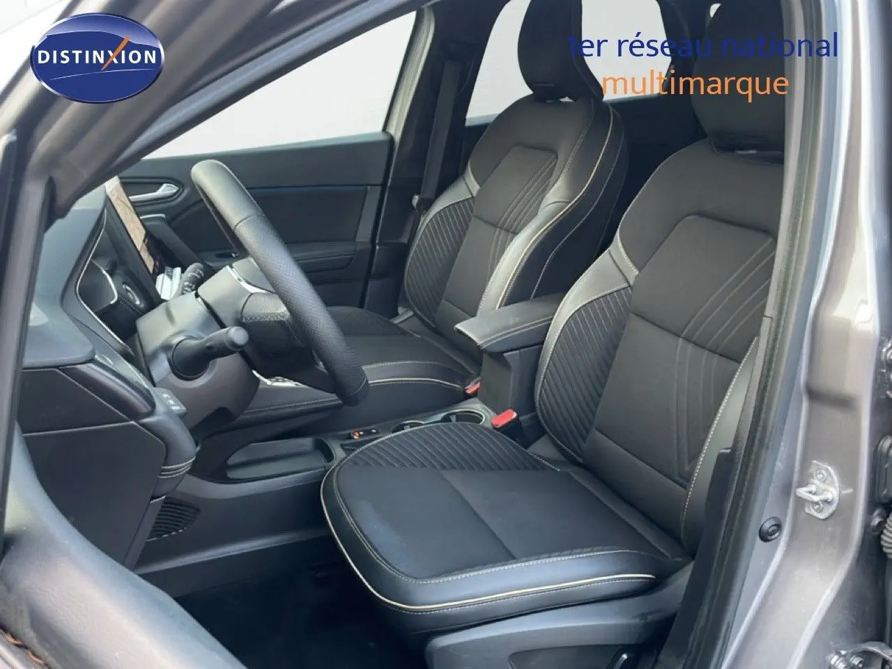 Intérieur de la Renault Symbioz 2025 en gris cassiopée, vue côté gauche montrant sièges noirs avec surpiqûres claires.