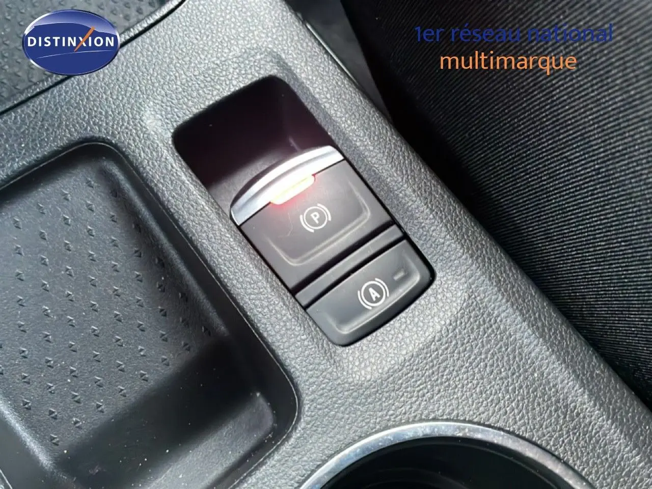 Gros plan sur la console centrale de la Renault Symbioz gris cassiopée, montrant les boutons de frein à main électrique et auto hold.