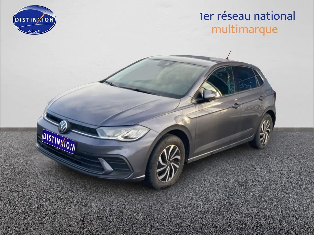 Volkswagen Polo gris cendre vue 3/4 avant droit sur sol gris avec jantes alliage distinctives.