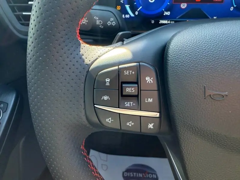 Gros plan sur le volant cuir perforé noir avec surpiqûres rouges du Ford Kuga 2.0 EcoBlue 120ch ST-Line 2024.