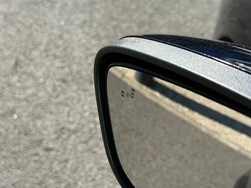 Gros plan sur le rétroviseur extérieur droit noir Agate Métallisé du Ford Kuga 2024 avec indicateur d'angle mort.