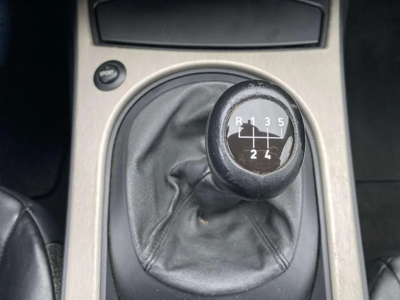 Le levier de vitesses manuel noir de la BMW Z4 Roadster 2.5i 2005 vu en gros plan sur la console centrale.