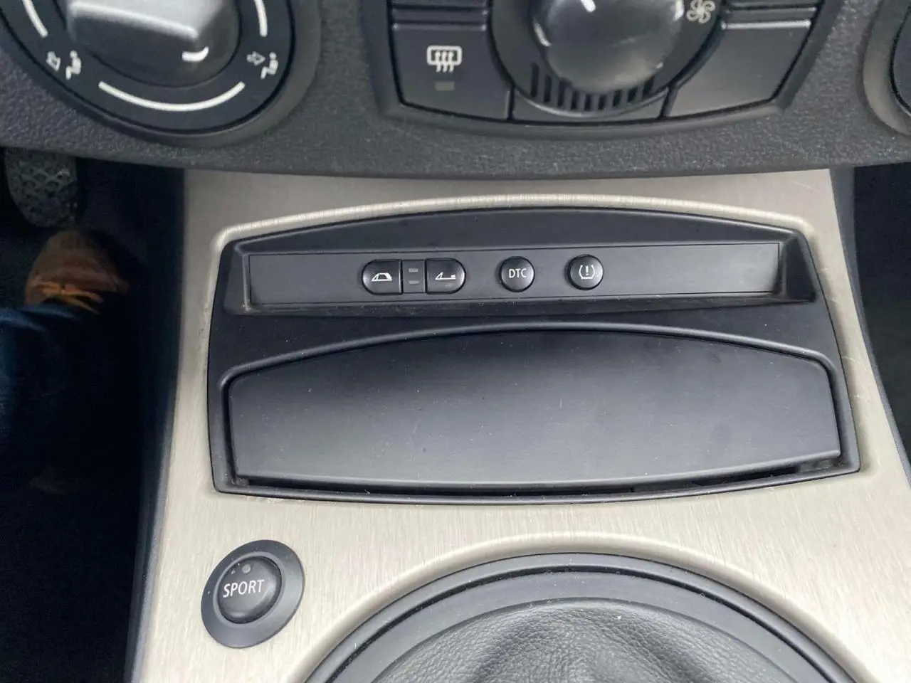 Gros plan sur la console centrale de la BMW Z4 Roadster 2005 avec bouton sport et commandes variées.