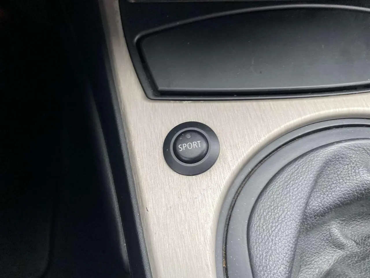 Gros plan sur le bouton sport et le levier de vitesse en cuir dans l’habitacle d’une BMW Z4 Roadster gris clair de 2005.