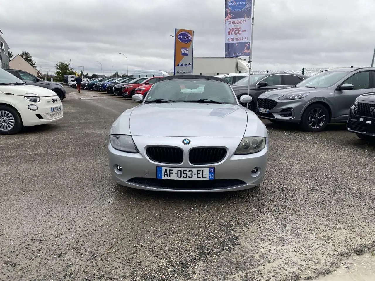 BMW Z4 Roadster gris clair vue de face, capote noire fermée, avec projecteurs antibrouillard et calandre caractéristique.
