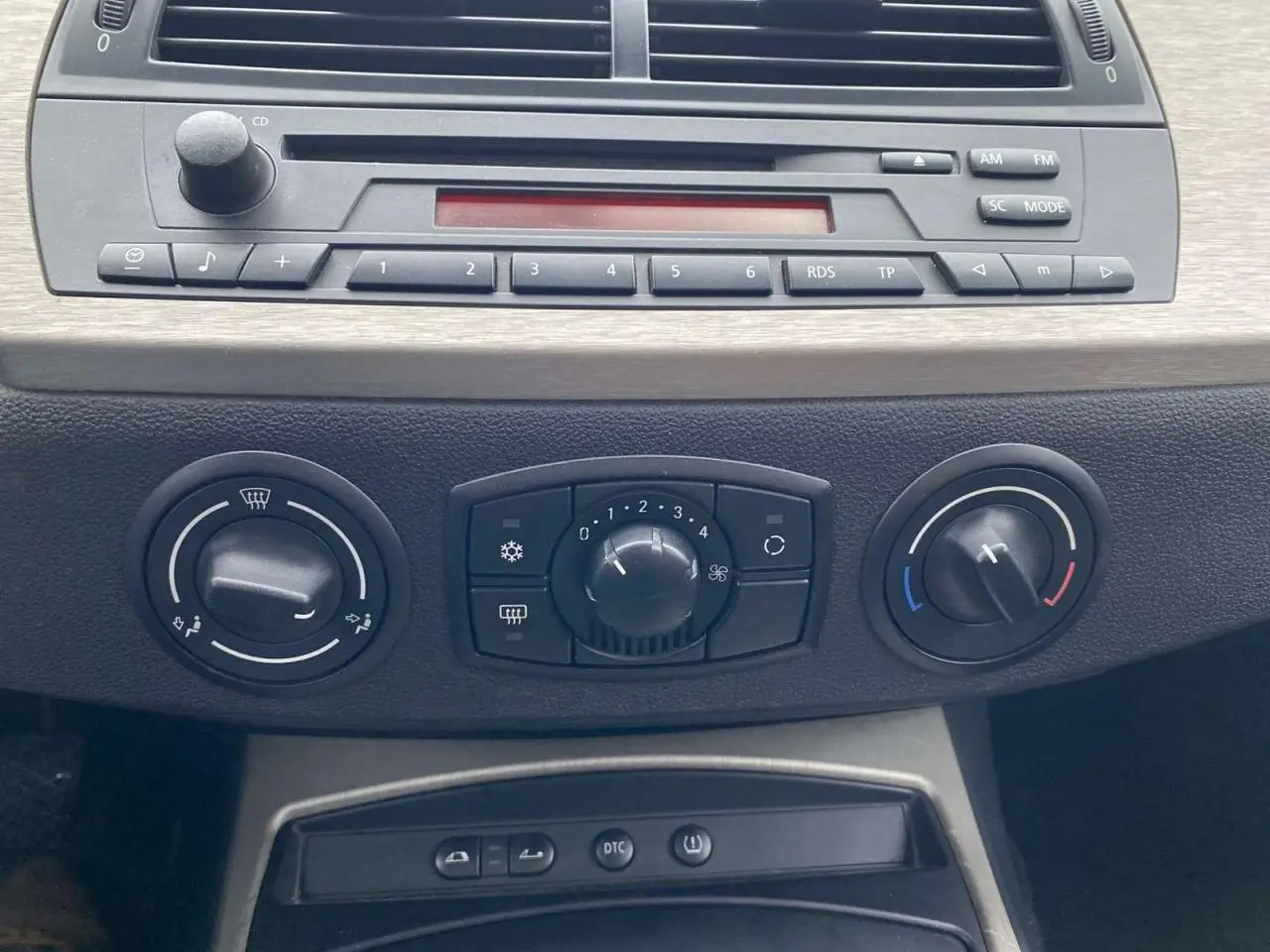 Vue rapprochée de la console centrale d’une BMW Z4 Roadster 2005, montrant les commandes de climatisation manuelle et l’autoradio CD.