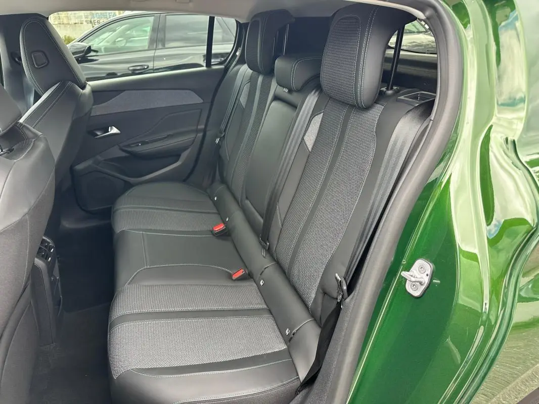 Vue intérieure côté droit sur les sièges arrière en tissu et cuir d'une Peugeot 308 vert foncé 2023.