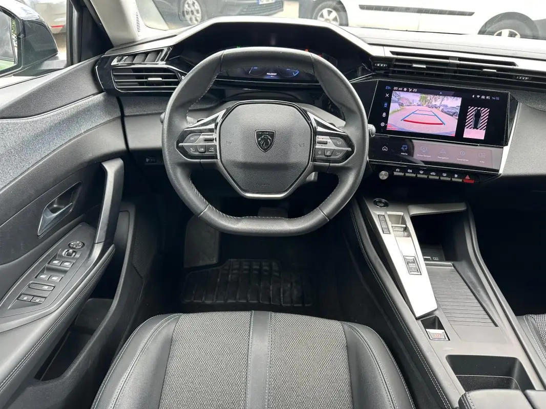 Vue intérieure centrée sur le volant Peugeot 308 2023 avec écran tactile affichant la caméra de recul.