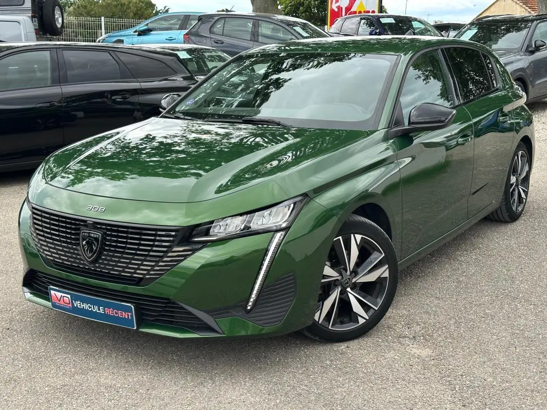 Peugeot 308 vert foncé vue 3/4 avant avec jantes alliage 17 pouces et calandre distinctive noire.