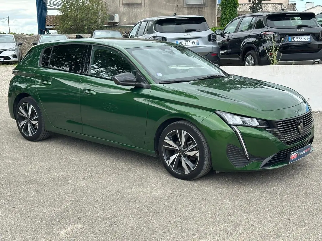 Peugeot 308 vert foncé vue 3/4 avant droit, avec jantes alliage 17 pouces et calandre distinctive noire.