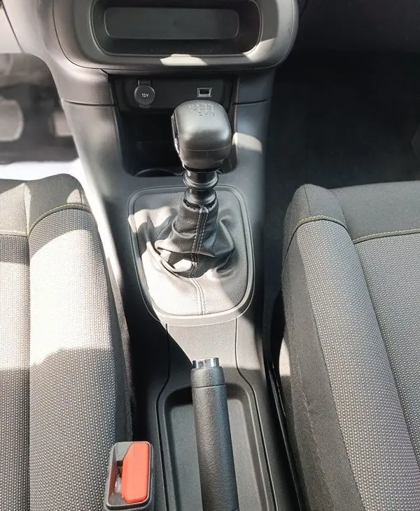 Vue plongeante sur la console centrale de la Citroën C3 Société blanche, mettant en valeur le levier de vitesses manuel et le frein à main.