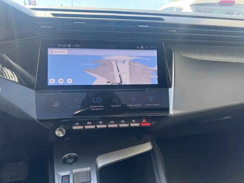 Vue rapprochée du tableau de bord de la Peugeot 308 Hybrid 145 Allure 2025 avec écran tactile de navigation allumé.