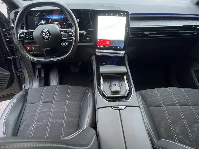 Intérieur du Renault Austral 2023 vu de face, volant cuir multifonction et écran tactile vertical lumineux.