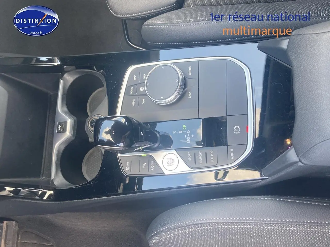 Vue rapprochée de la console centrale noire brillante avec levier de vitesse et commandes d'une BMW Série 1 118i 2023.