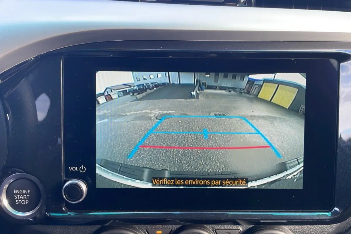 Écran multimédia du Toyota Hilux 2025 affichant la caméra de recul avec lignes de guidage en bleu et rouge.
