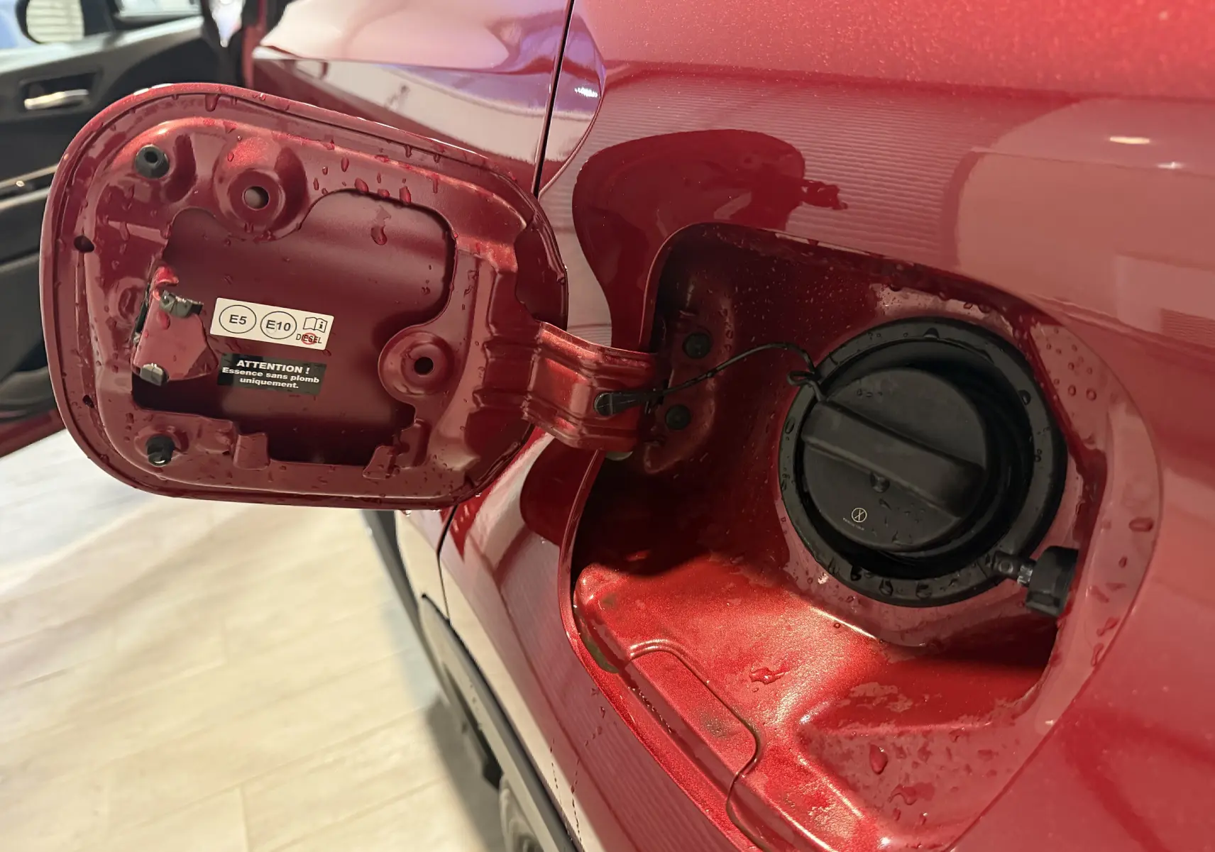 Vue rapprochée de la trappe à carburant rouge ouverte côté gauche du Toyota C-HR Hybride 2018.