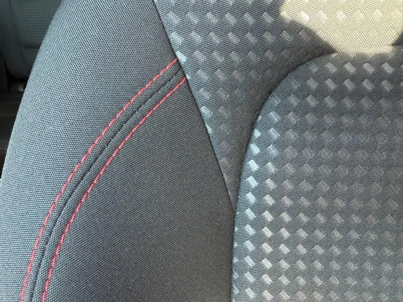 Gros plan sur le tissu noir Foundry/Eton avec surpiqûres rouges du siège avant sport du Ford Kuga 2024.