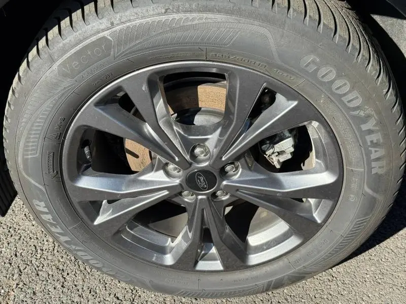 Gros plan sur la jante alu grise et pneu Goodyear du Ford Kuga 2.0 EcoBlue 120ch ST-Line 2024 bleu Abysse.
