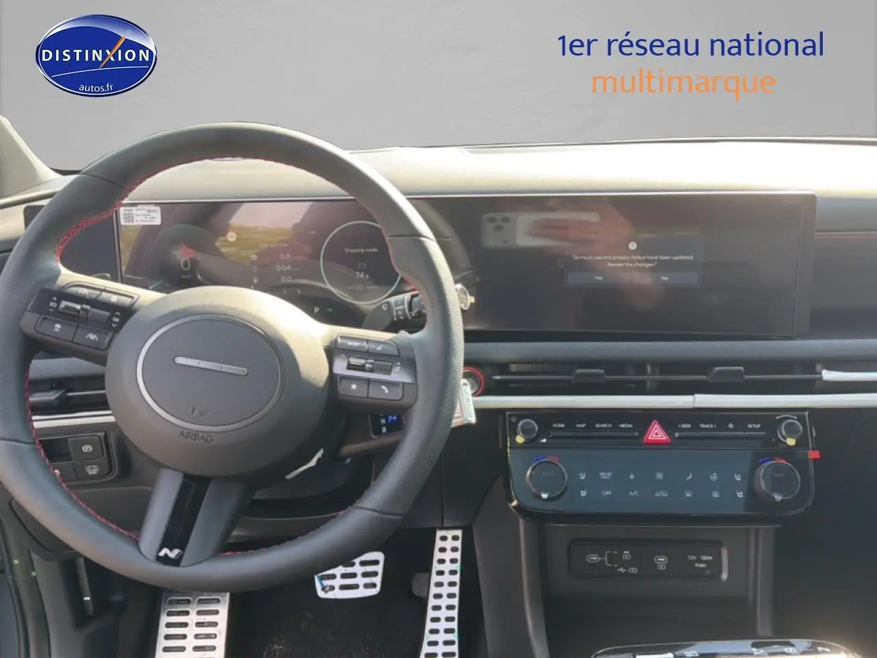 Vue intérieure du tableau de bord et volant cuir noir avec surpiqûres rouges du Hyundai Tucson 2026 gris shadow.