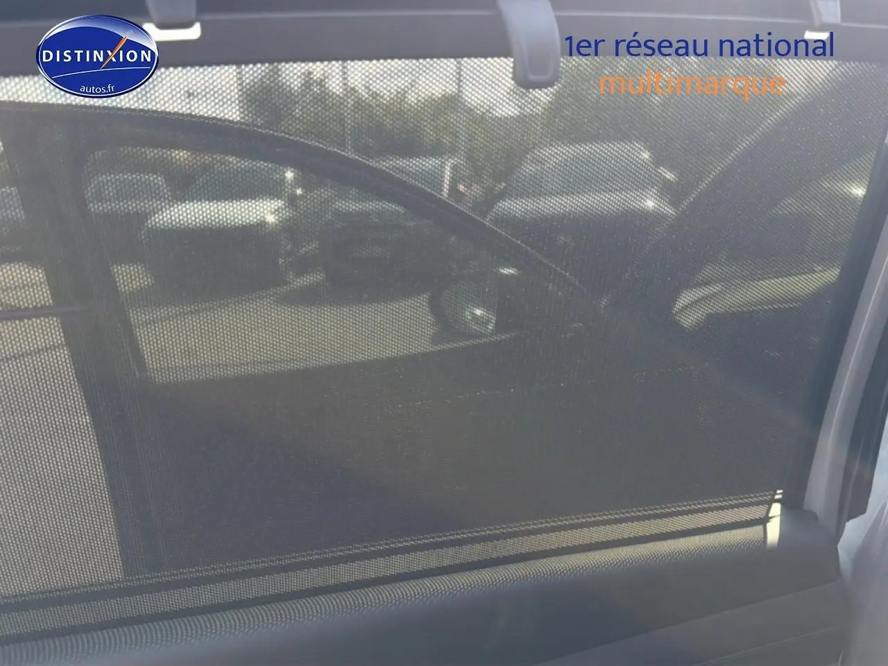 Vue intérieure côté gauche du Hyundai Tucson gris shadow avec pare-soleil en filet et rétroviseur extérieur visible.