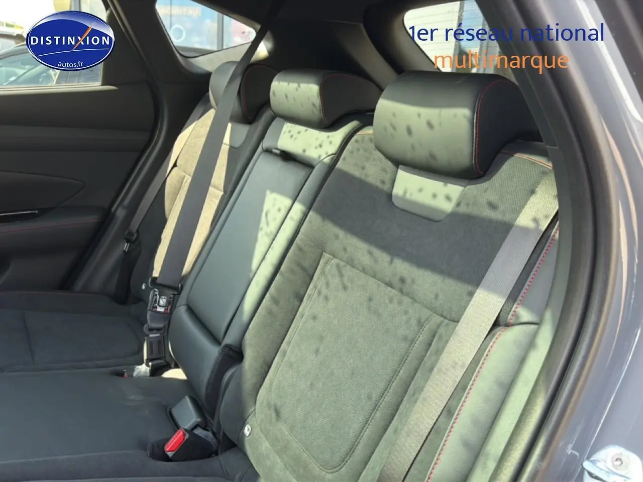 Vue intérieure côté droit sur la banquette arrière en cuir noir et alcantara avec surpiqûres rouges du Hyundai Tucson gris shadow 2026.