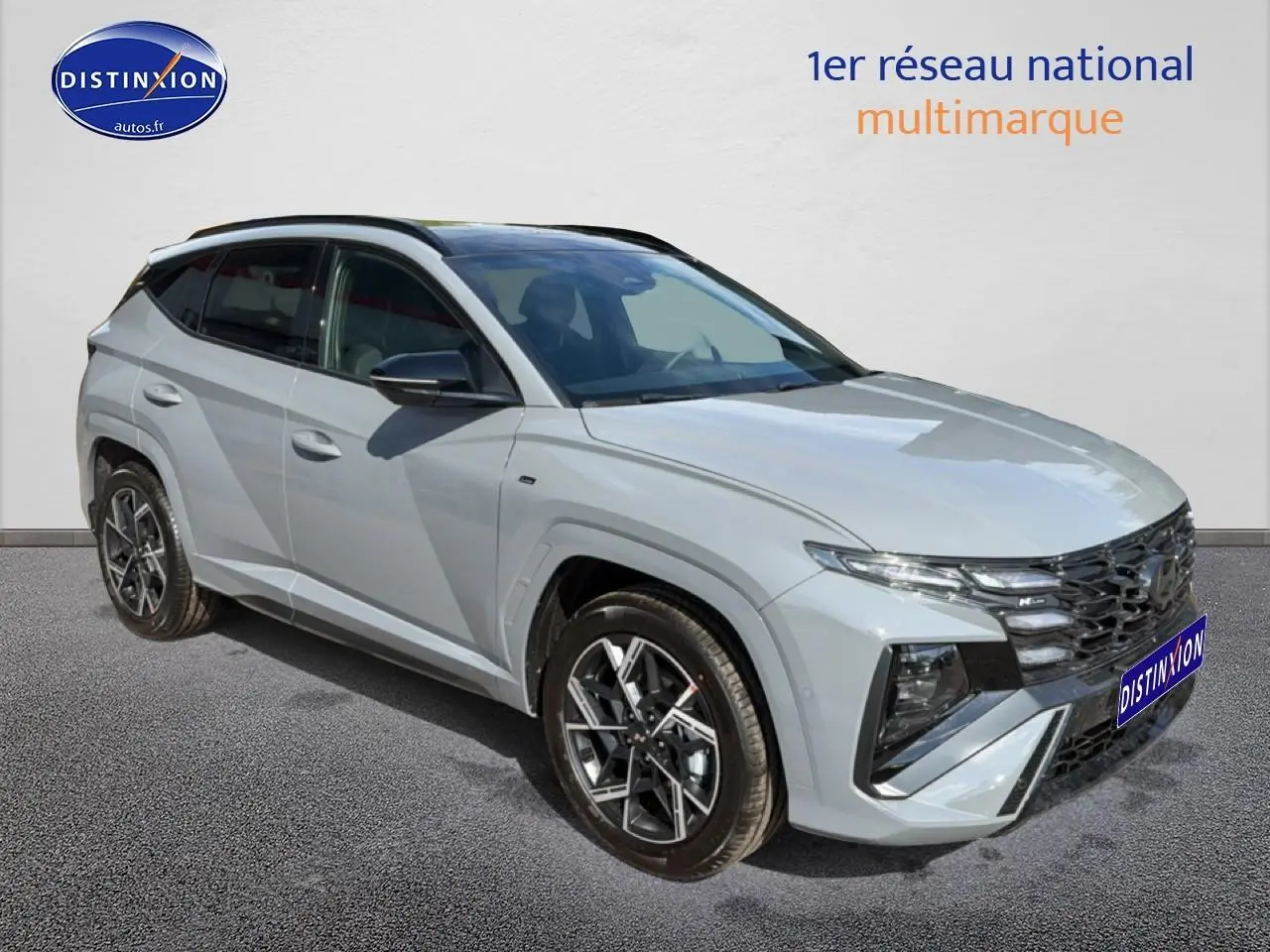 Hyundai Tucson 2026 gris shadow en 3/4 avant droit avec calandre noire et jantes alu distinctives.