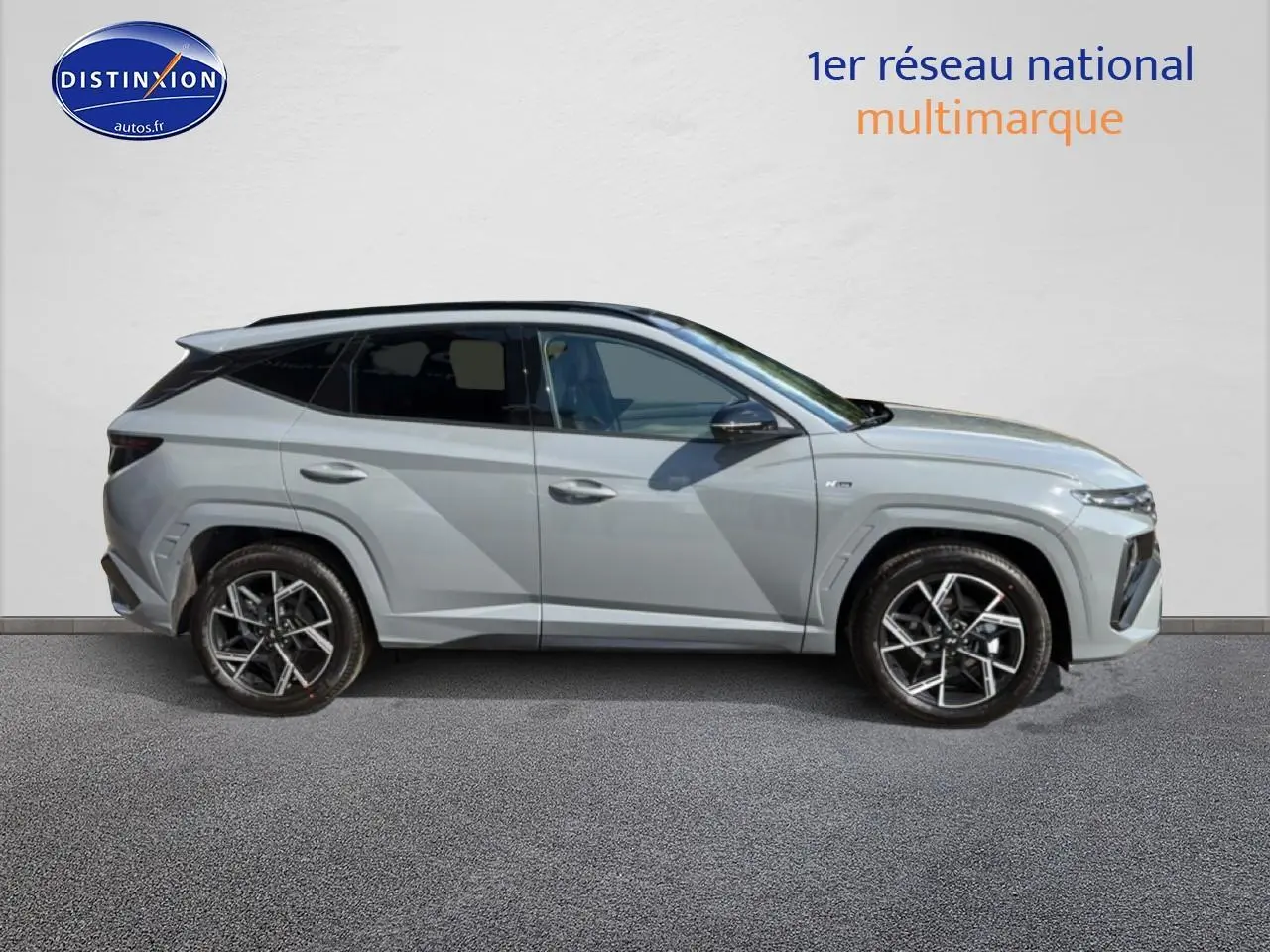 Vue de profil côté gauche du Hyundai Tucson 2026 gris shadow avec jantes alliage et toit panoramique noir.