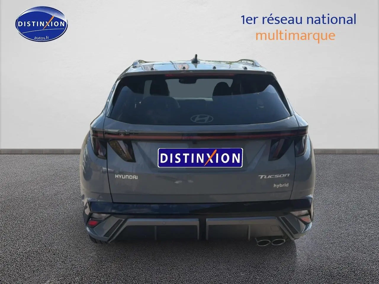 Vue arrière d'un Hyundai Tucson gris shadow hybride avec feux arrière LED et double sortie d'échappement à droite.