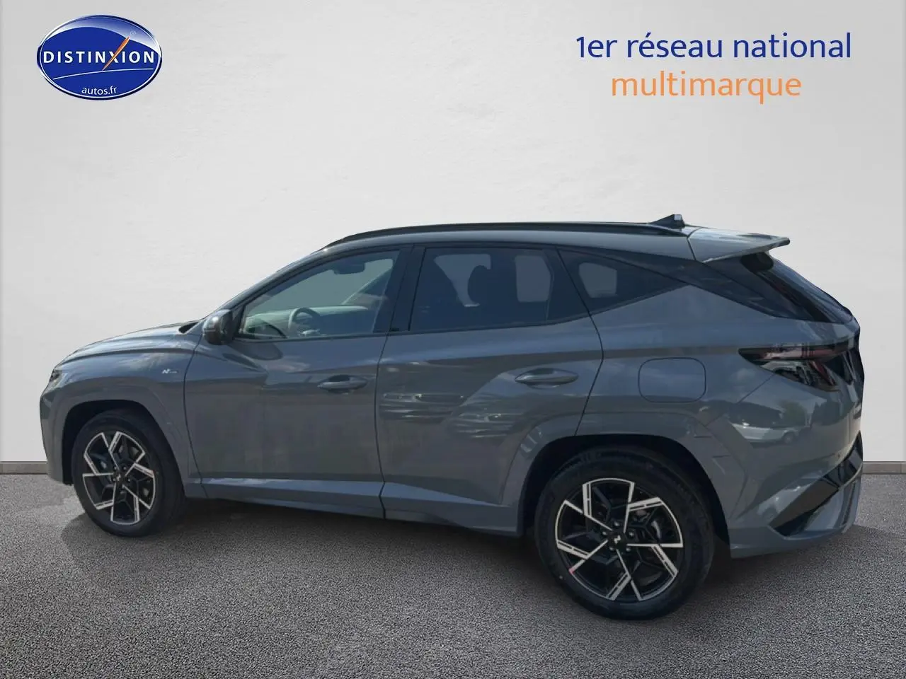 Hyundai Tucson 1.6 t-gdi 239 hybride N Line gris shadow vu de profil côté gauche, jantes alu noires et toit noir.