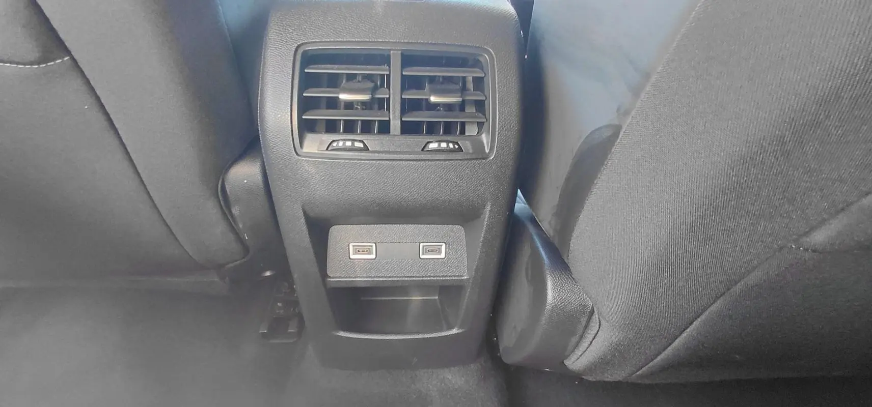 Vue rapprochée de la console arrière avec bouches d’aération et deux ports USB du Peugeot 308 gris 2025.