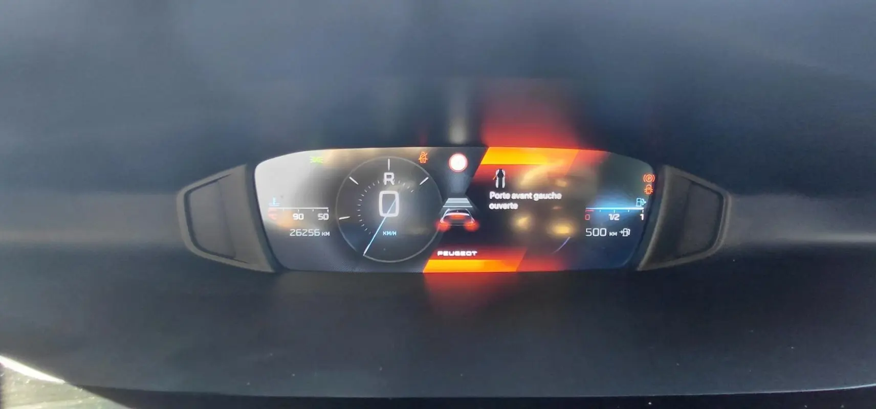 Affichage numérique du cockpit de la Peugeot 308 gris, indiquant porte avant gauche ouverte et vitesse à 0 km/h.