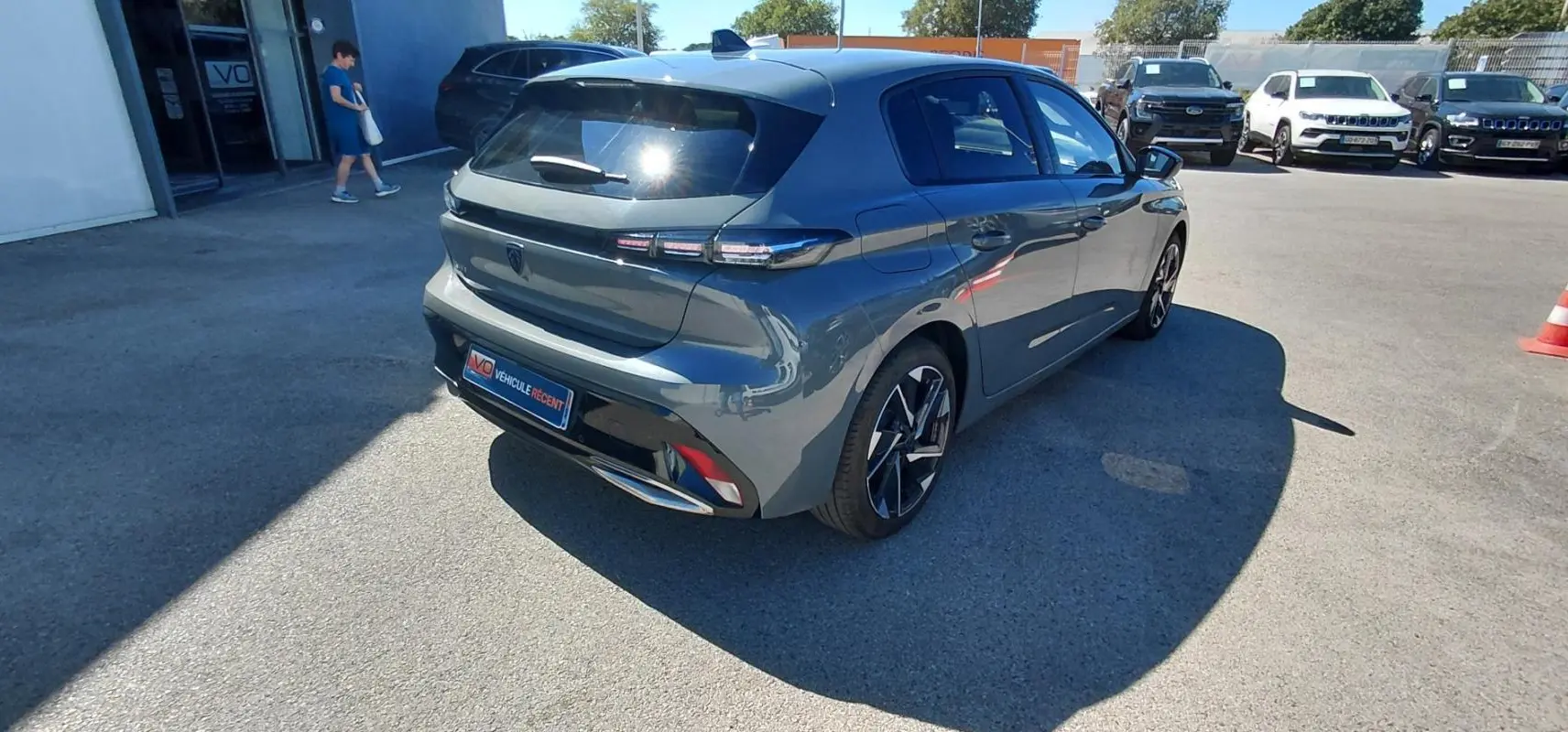 PEUGEOT 308 gris vue 3/4 arrière droit, avec feux arrière LED et jantes alliage distinctives.