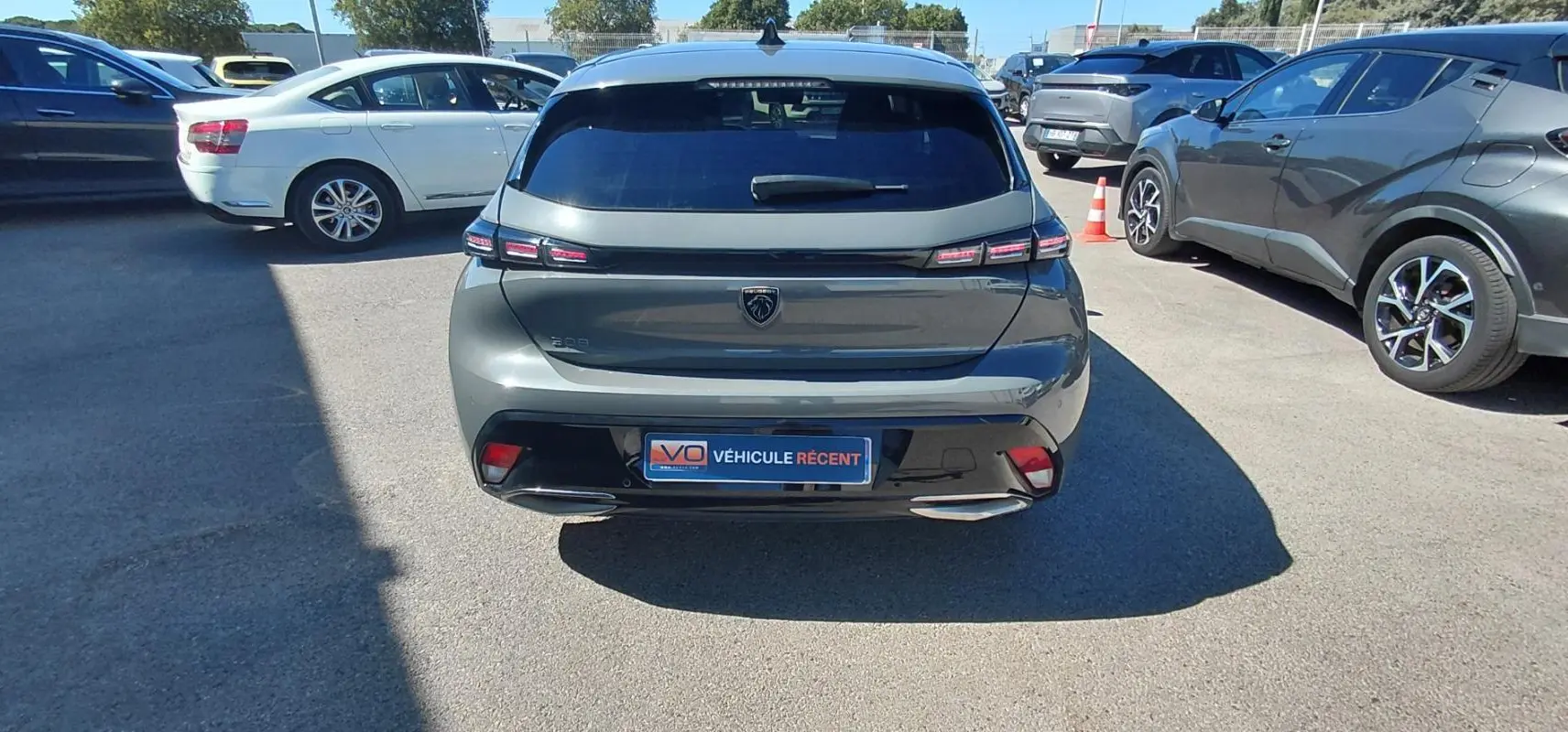 Vue arrière d'une Peugeot 308 gris métallisé 2025 avec feux LED et double sortie d'échappement visible en extérieur.