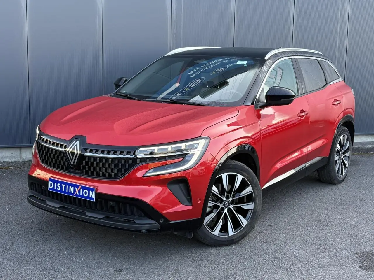 Renault Austral E-Tech rouge Flamme en 3/4 avant droit avec toit panoramique noir étoilé et jantes alliage noires.