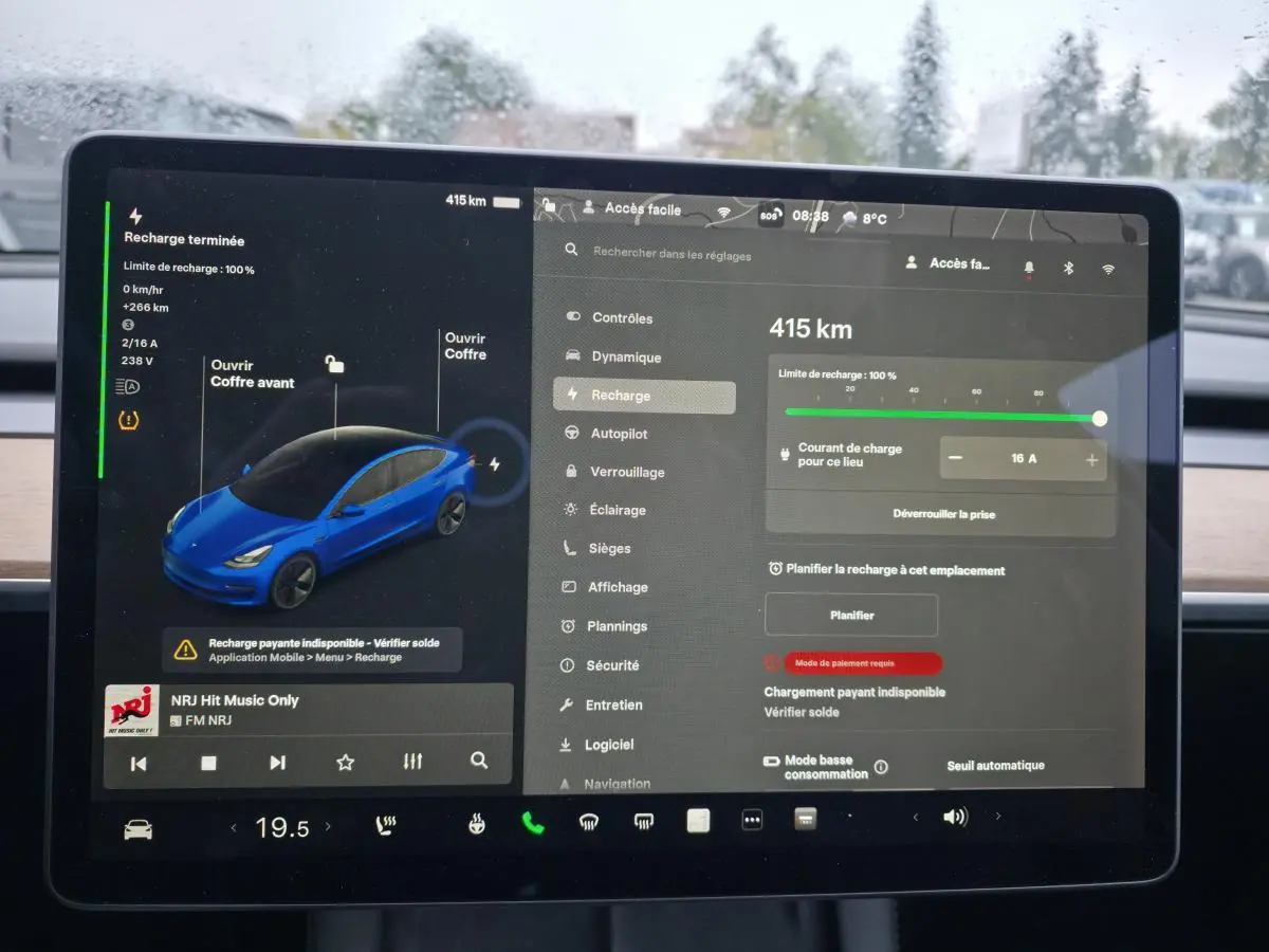 Écran tactile intérieur de Tesla Model 3 bleu foncé affichant l'état de recharge et les réglages du véhicule.