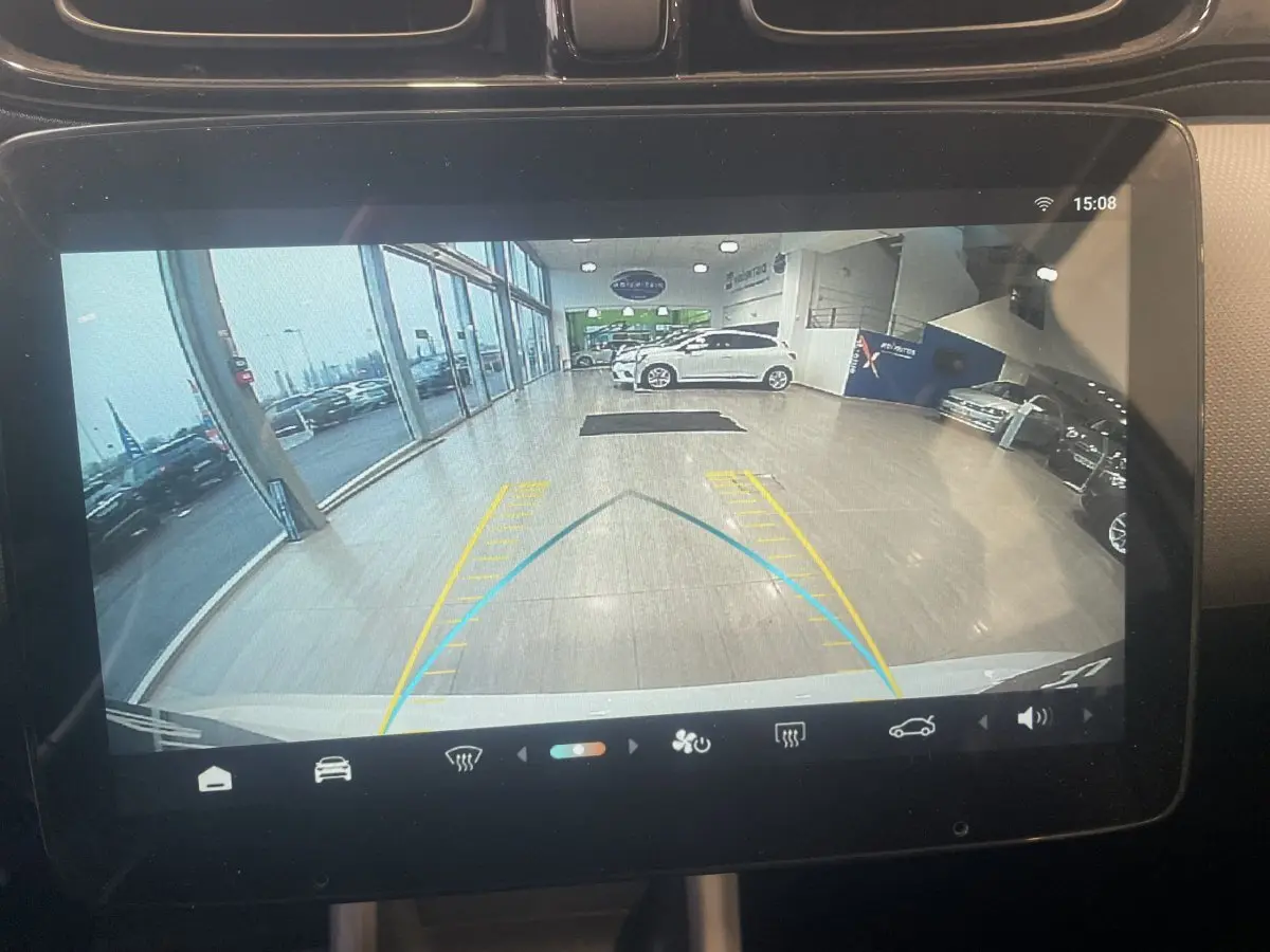 Écran tactile intérieur montrant la caméra de recul d'une LEAPMOTOR T03 Luxury blanche en showroom.