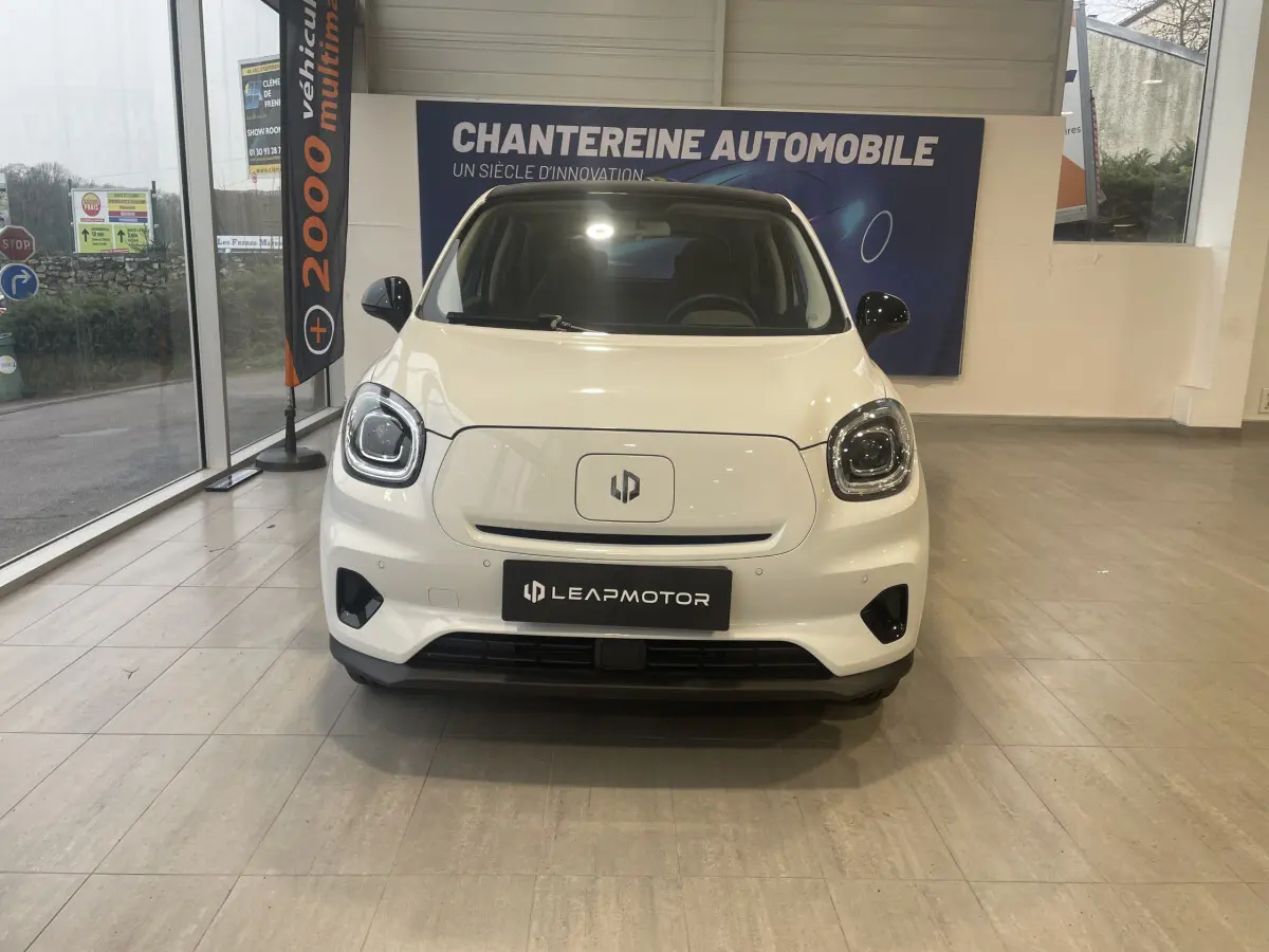 Vue de face du LEAPMOTOR T03 Luxury blanc, mettant en valeur ses phares LED et son logo central sur fond lisse.