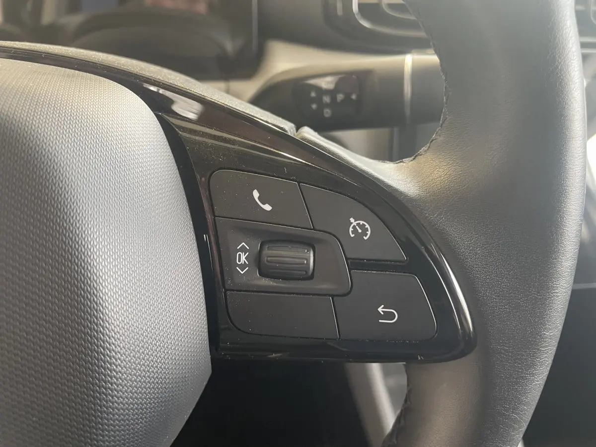 Gros plan sur le volant cuir noir du Leapmotor T03 Luxury 2025, avec commandes multifonctions visibles.