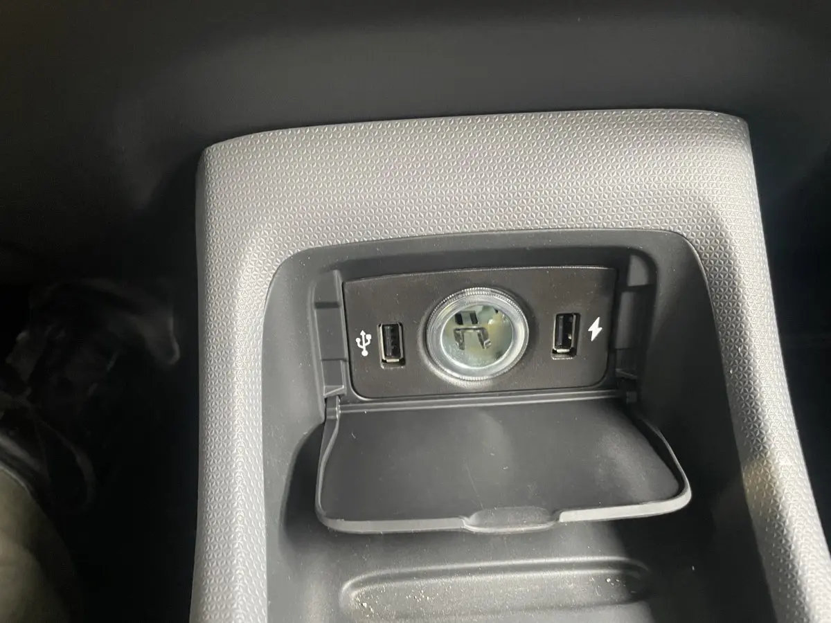 Gros plan sur la prise 12V et ports USB intégrés dans la console centrale du Leapmotor T03 Luxury blanc.