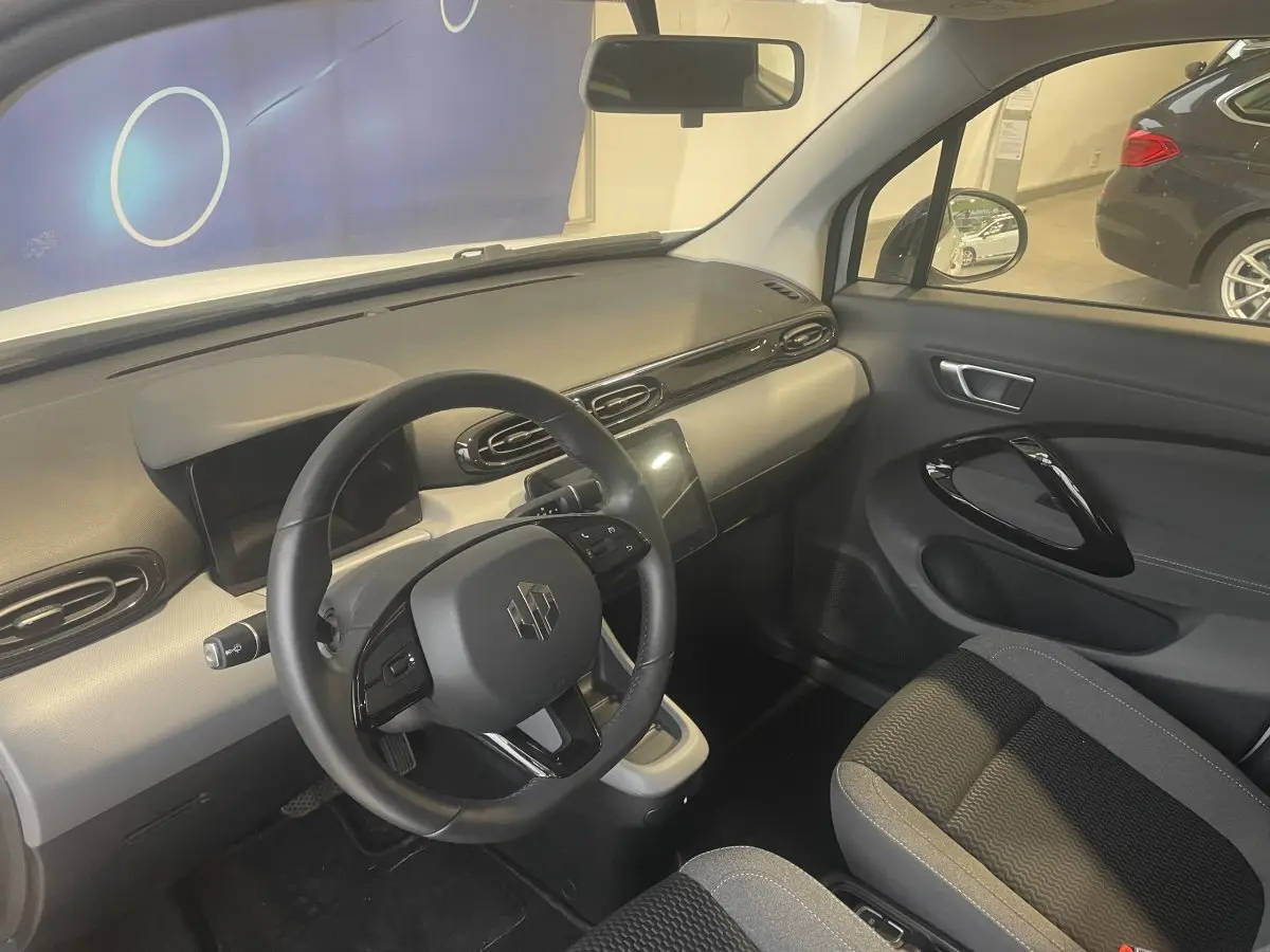 Vue intérieure côté conducteur du Leapmotor T03 Luxury 2025, volant cuir multifonctions et tableau de bord moderne gris et noir.