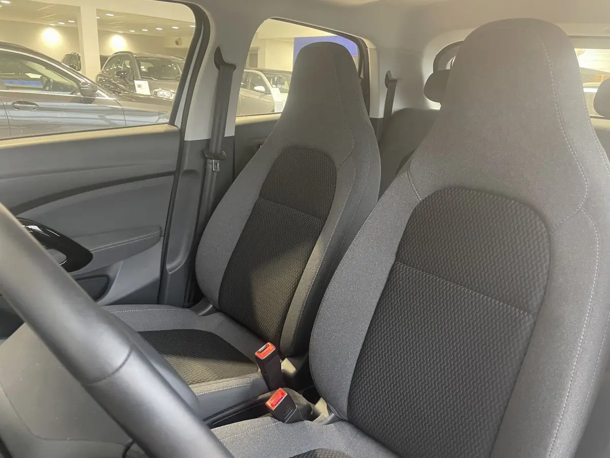 Vue intérieure rapprochée des sièges avant gris et noirs du LEAPMOTOR T03 Luxury 2025, avec volant partiel visible.