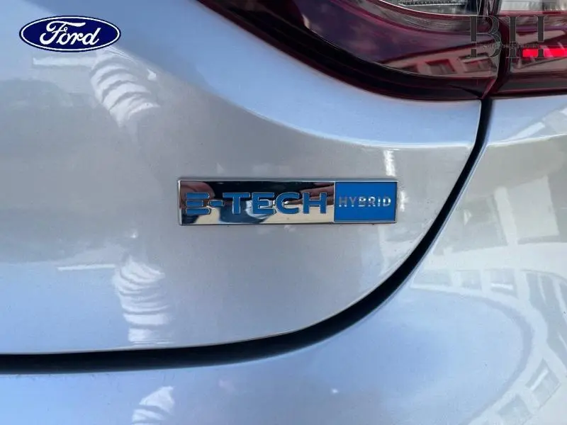 Gros plan sur l'arrière gris platine d'une Renault Clio 1.6 E-Tech hybride 145ch avec logo E-TECH Hybrid visible.