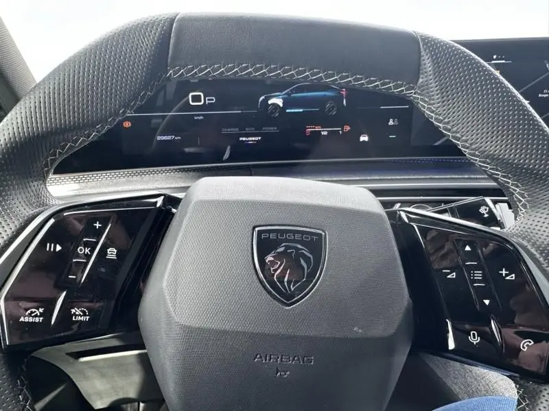 Vue intérieure centrée sur le volant gris et le tableau de bord numérique du Peugeot 3008 Nouveau 1.2 hybrid 2024.