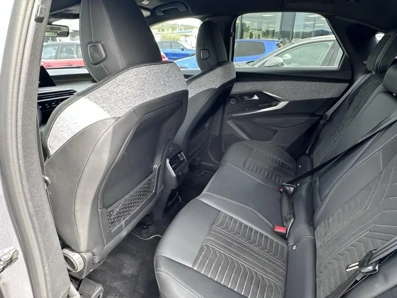 Vue intérieure arrière du Peugeot 3008 2024 gris métal, montrant les sièges arrière en cuir et tissu avec ceinture de sécurité.