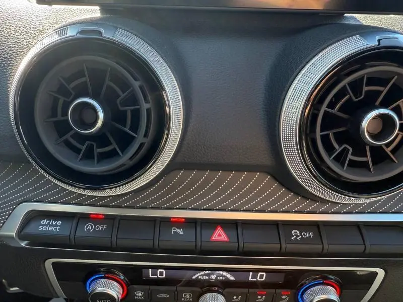 Détail intérieur montrant les aérateurs ronds et la console centrale du tableau de bord de l'Audi Q2 35 TDI S line 2025.