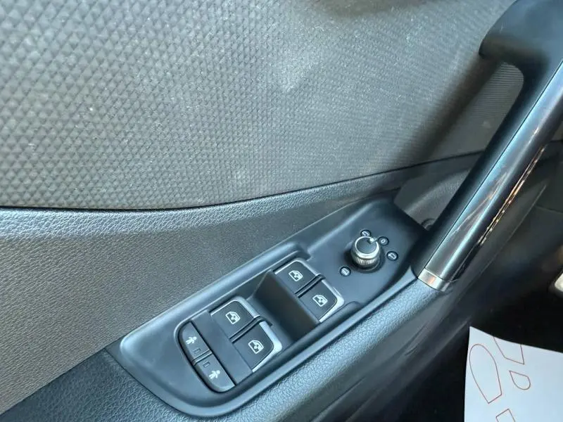 Détail du panneau de commandes des vitres et rétroviseurs côté conducteur de l'Audi Q2 35 TDI S line gris Daytona nacré.